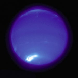 Neptune glows blue against a black background, with a single while spot on its southern side.